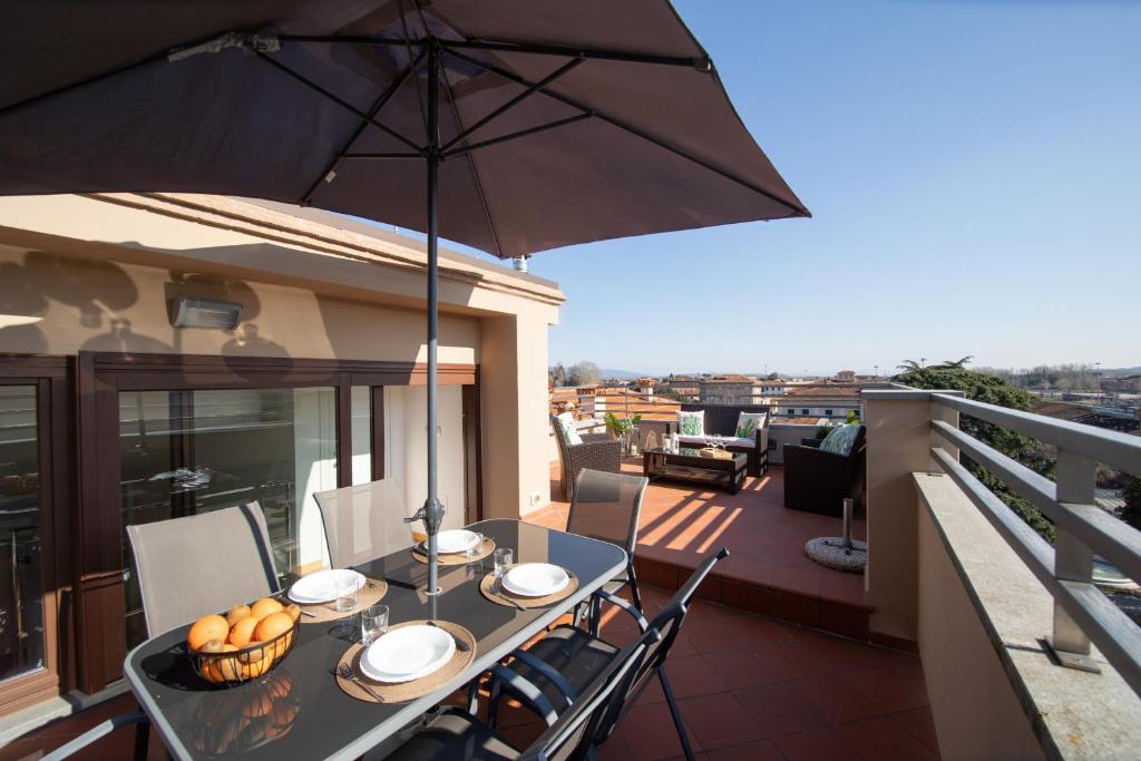 - une table sur un balcon avec un parasol dans l'établissement Rooftop Delight with Terrace, à Lucques