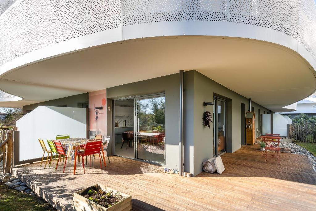 a patio with a table and chairs on a deck at Iri Etxea - Appt 2 chambre à Bayonne in Bayonne