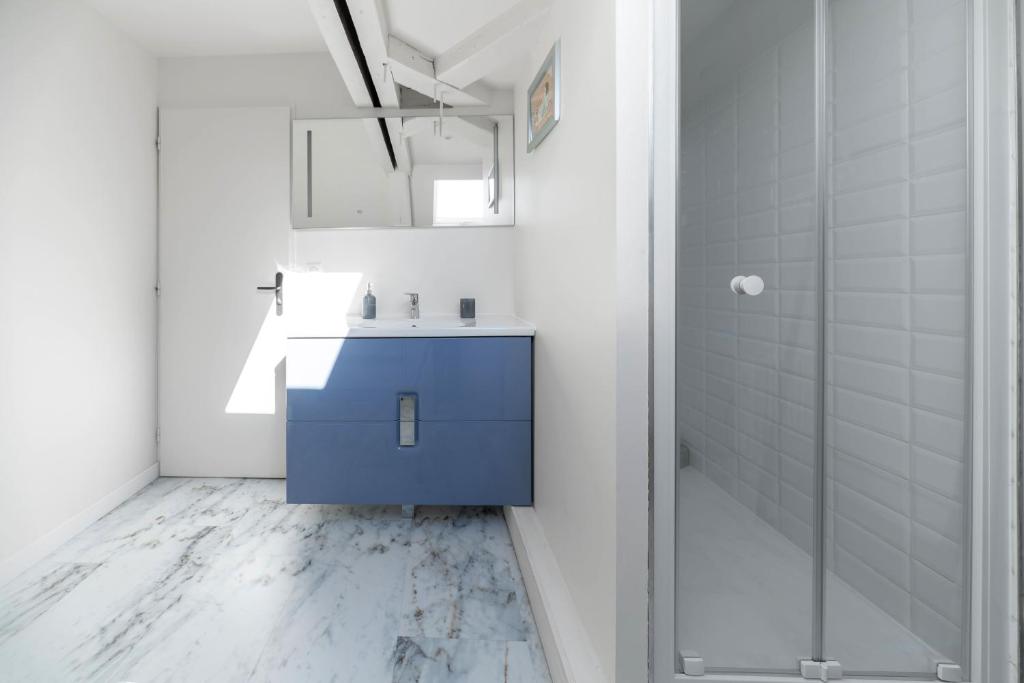 a bathroom with a blue sink and a shower at La Grande Maison Gannat in Gannat