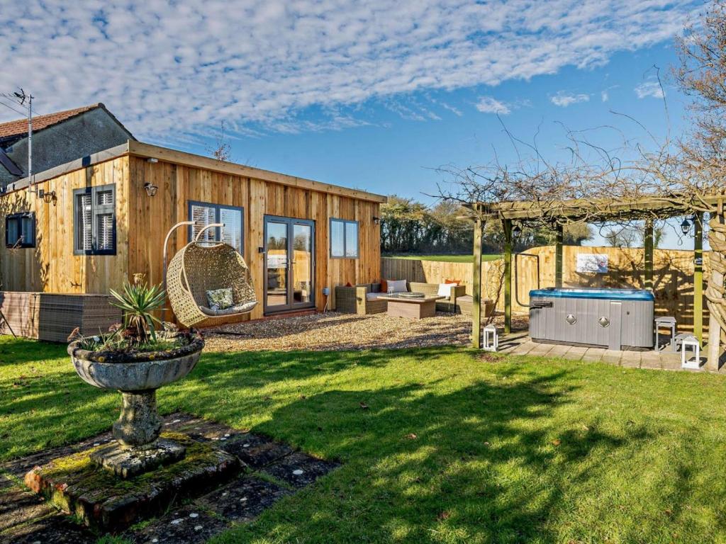 une maison en bois dans une cour avec une grande sidx dans l'établissement Log Cabin near Bath, à Chippenham