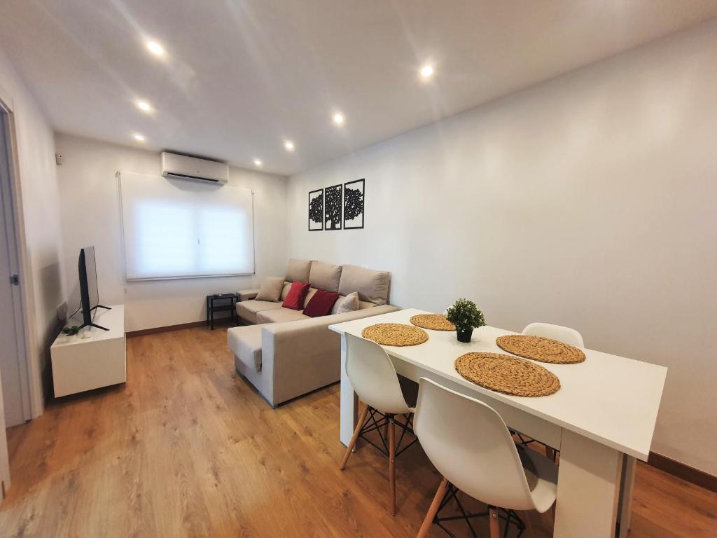 Una sala de estar con una mesa y sillas y un sofá. en Apartamento nuevo a 5 Minutos de la Playa, en Platja d'Aro