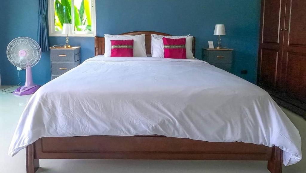 a bedroom with a large white bed with pink pillows at Lay Back Villa C1with kitchen & High Speed Internet in Krabi