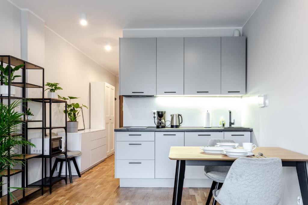 a kitchen with white cabinets and a table and chairs at Studio w centrum- Villa Wenecja in Poznań