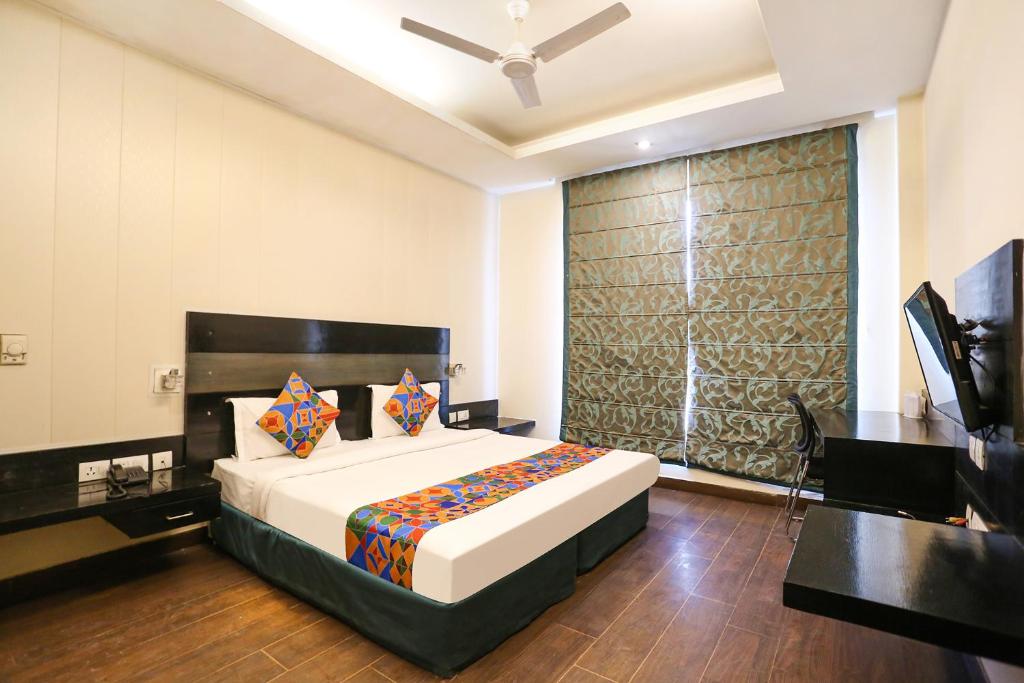 a bedroom with a large bed and a television at FabHotel Posh Classic in Gurgaon