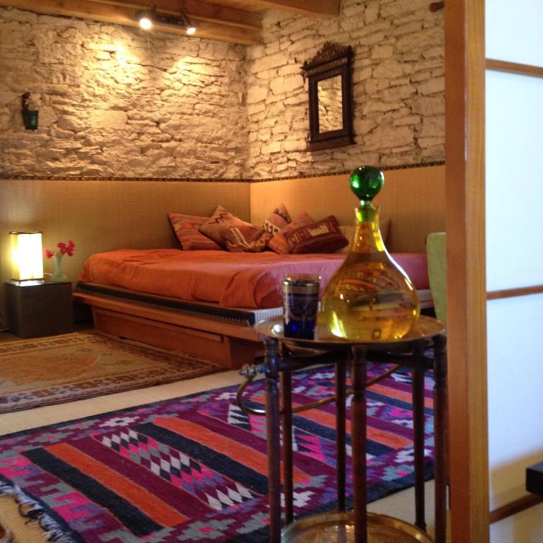 sypialnia z łóżkiem i butelką na stole w obiekcie gîte pour amoureux ambiance Japon w mieście Rebourguil