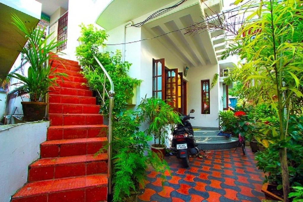 a red staircase in a building with plants at ChristVille in Cochin