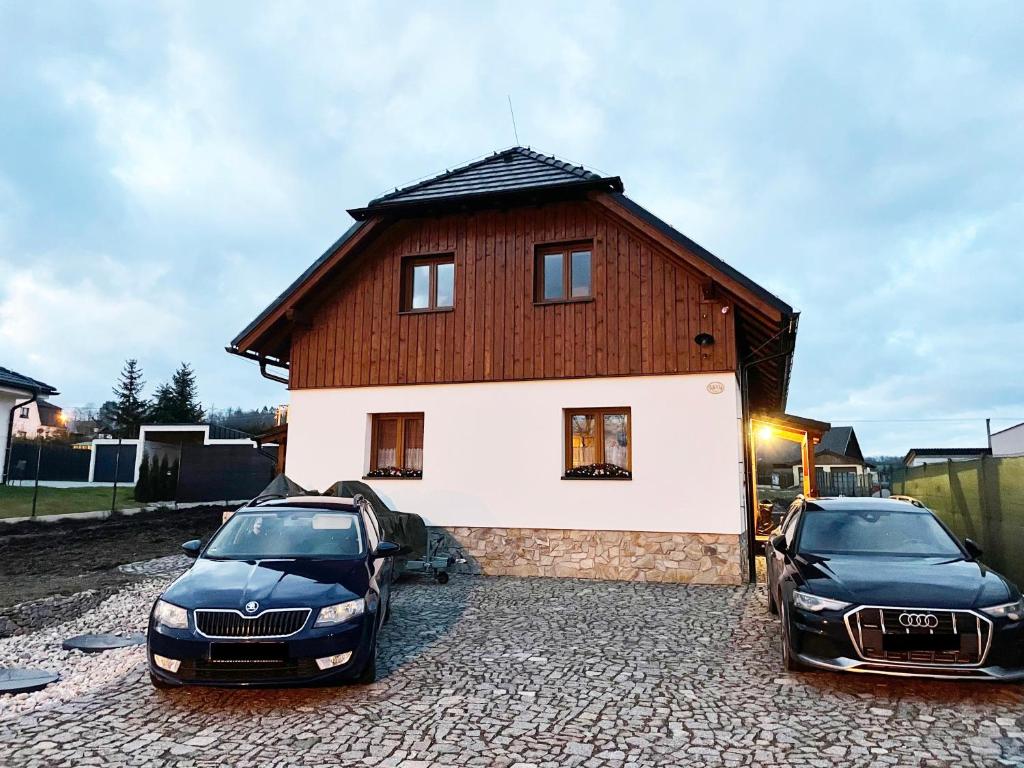 two cars parked in front of a house at Chalupa Luční Kvítí in Petrovice u Susice