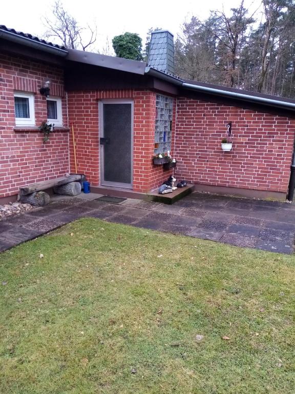 a red brick house with a yard in front of it at Ferienhaus Heidekate in Munster