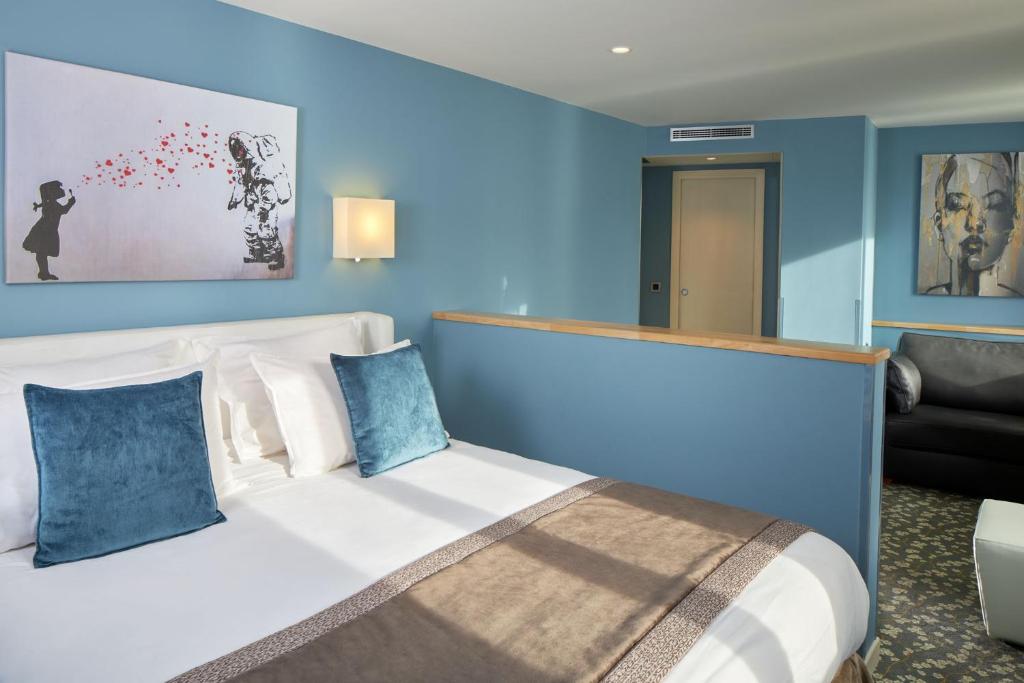 a bedroom with a large bed with blue walls at Grand Hôtel Malher in Paris