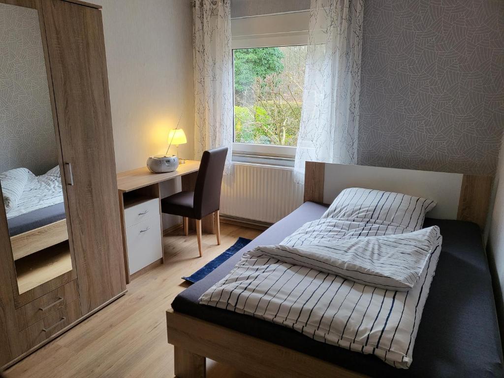 a bedroom with a bed and a desk and a window at Ferienhaus Heidekate in Munster im Heidekreis