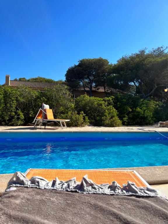 una piscina con acqua blu accanto a un tavolo di CASA VALENTINA VIVIENDA TURISTICA ET6135 a Es Caló de Sant Agustí