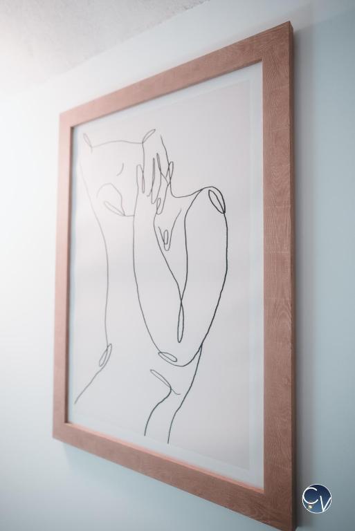 a drawing of a woman in a frame on a wall at Appartement neuf et moderne dans le centre ville in Bagnols-sur-Cèze