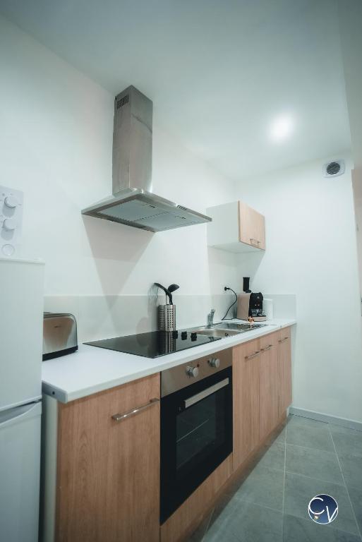 a kitchen with a sink and a stove top oven at Appartement neuf et moderne dans le centre ville in Bagnols-sur-Cèze