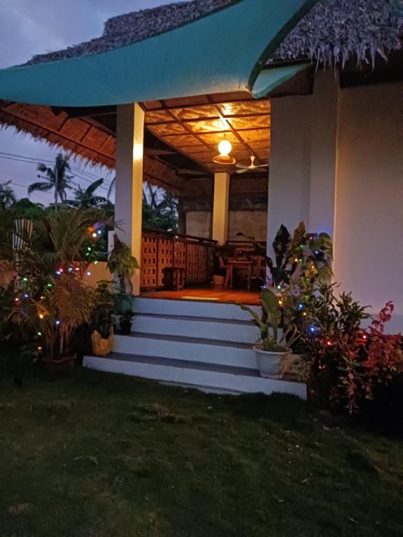 Weeroona Huts Homestay Pacifico في San Isidro: الشرفة الأمامية للمنزل مع الفناء