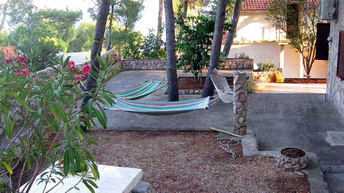 a hammock in a yard next to a house at Apartmani Diego in Sveta Nedelja