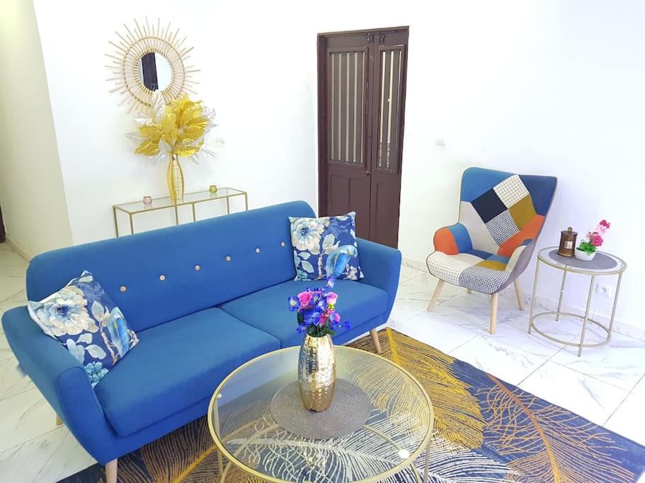 un sofá azul y una mesa en la sala de estar en Charmant F3, 2 chambres + salon à Yoff plage bceao, en Dakar