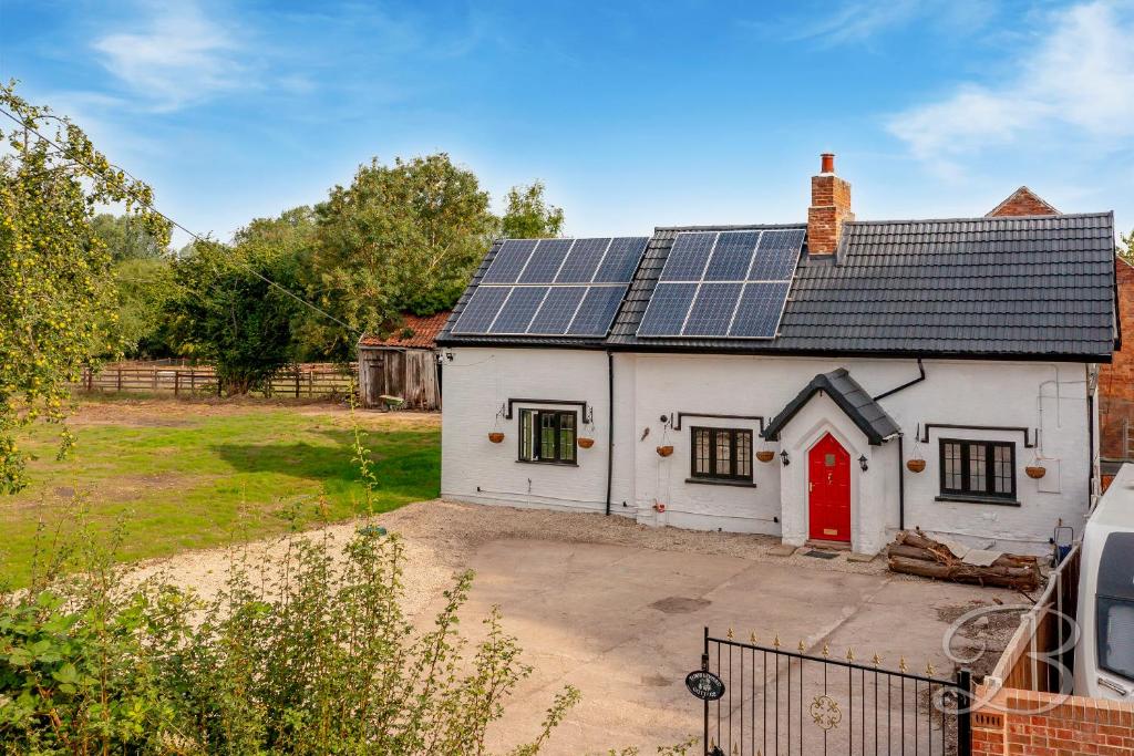 Casa blanca con paneles solares en el techo en Tumbleweed Cottage en Newark upon Trent