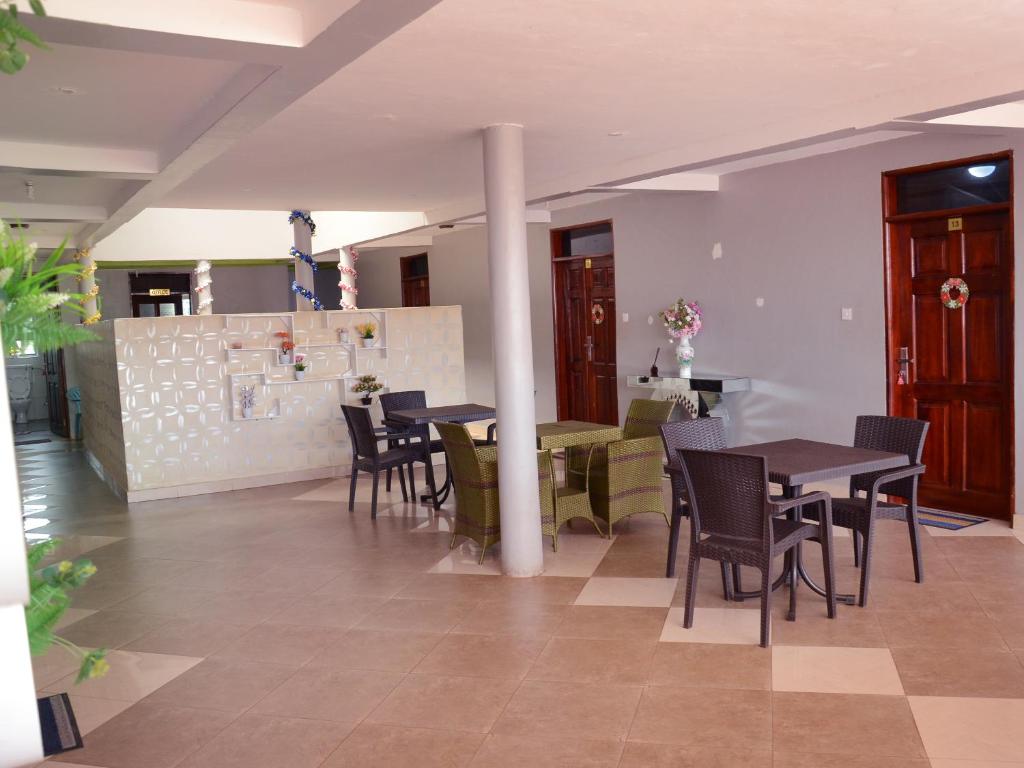 a restaurant with tables and chairs in a room at CS HOTEL in Hoima