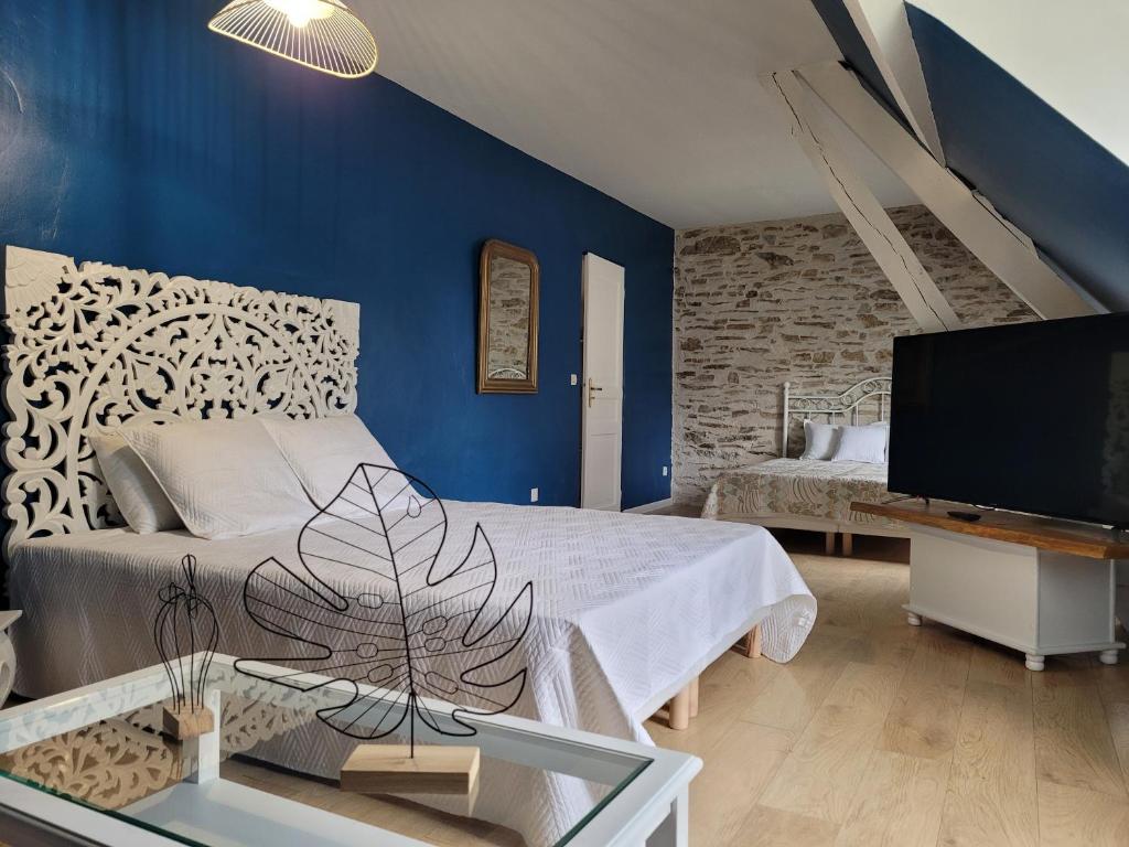 - une chambre avec un lit, une télévision et des murs bleus dans l'établissement Domaine des grands chênes, à Préveranges