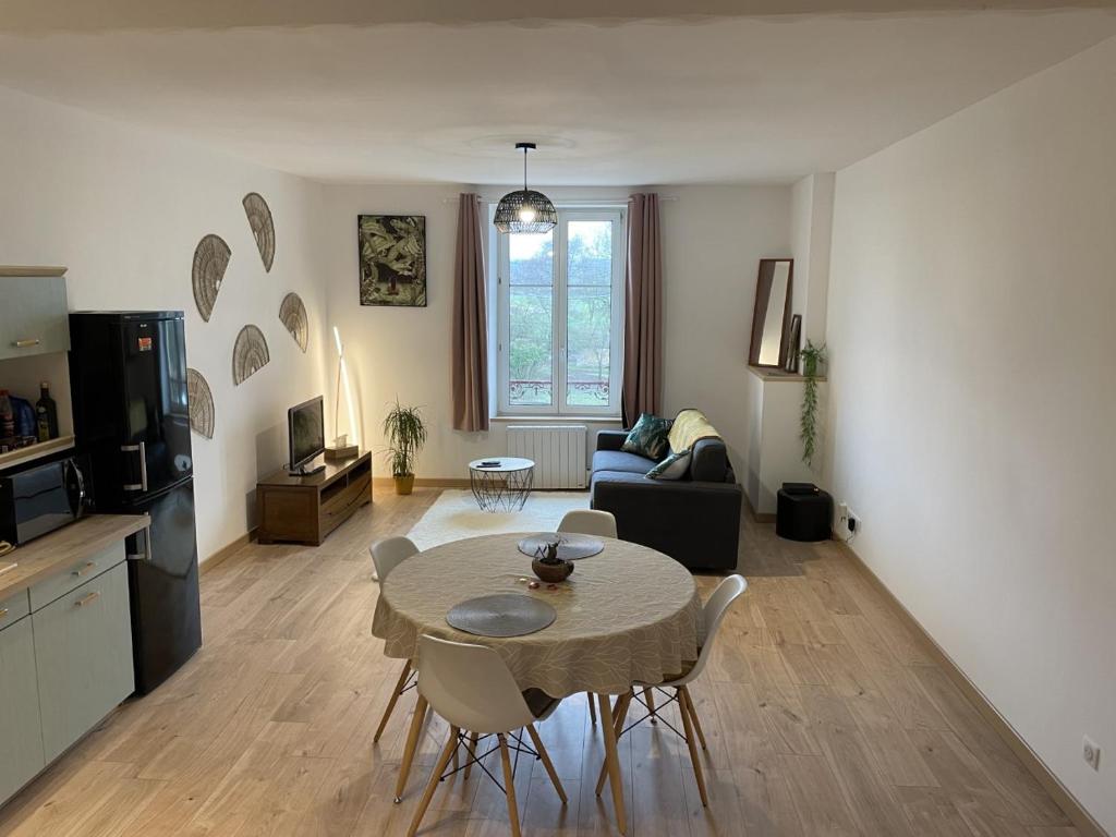 ein Wohnzimmer mit einem Tisch und Stühlen in der Unterkunft Appartement confortable proche des commodités in Moncel-lès-Lunéville