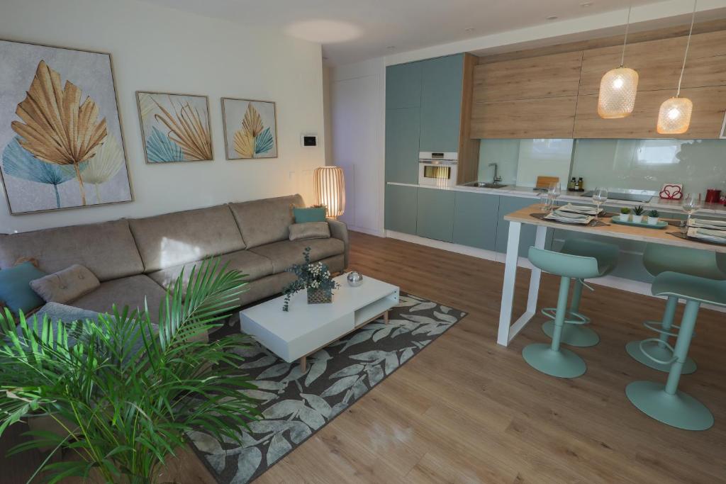 a living room and kitchen with a couch and a table at APARTAMENTOS LOS QUESEROS in Quintanadueñas