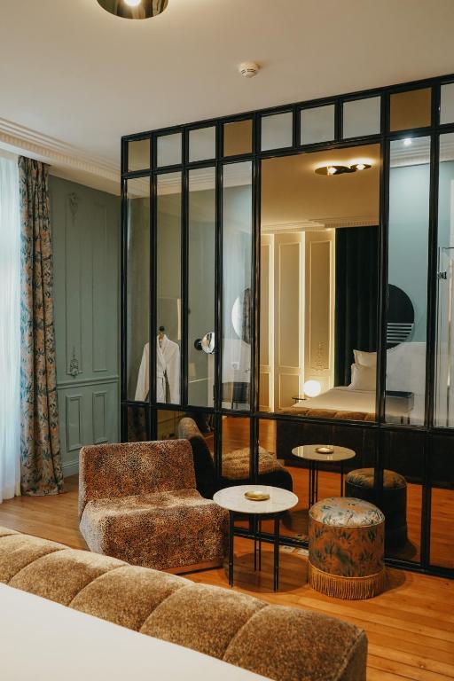 a living room with a couch and a bedroom at Hôtel Singulier Bordeaux - Boutique Hôtel & Spa Anne Semonin in Bordeaux