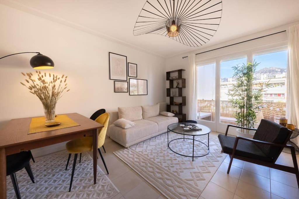 uma sala de estar com um sofá e uma mesa em 06B - Beau 2 pièces rénové avec terrasse vue mer em Roquebrune-Cap-Martin