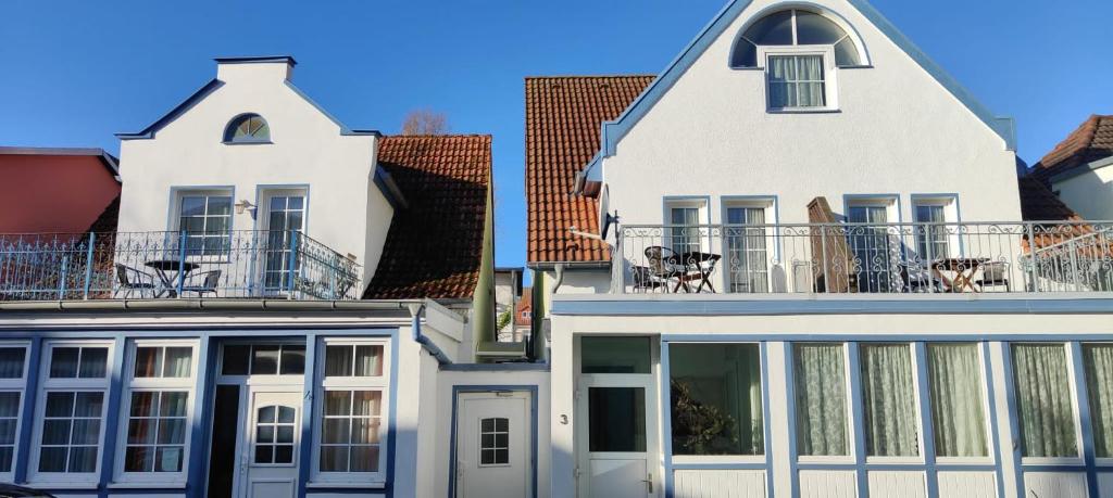 a white house with a balcony on top of it at Hotel Zum Strand in Warnemünde