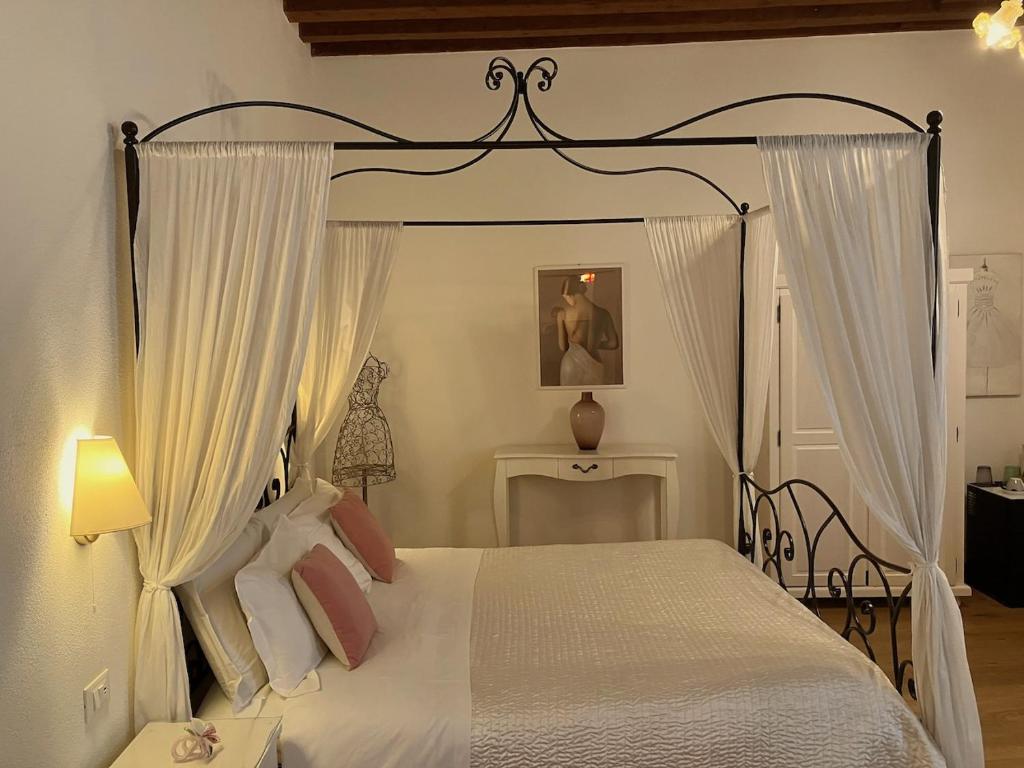 een slaapkamer met een hemelbed en witte gordijnen bij Residenza Corte Antica in Venetië