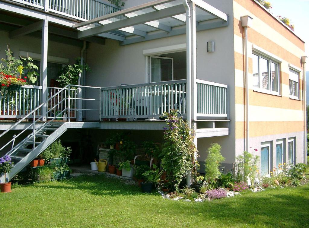 a house with a balcony with plants and flowers at Ferienwohnung Kern in Bodensdorf