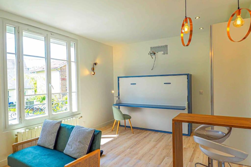a living room with a blue couch and a large whiteboard at Studio de Luxe Meublé ,Clim et Parking Options, lave-linge in Bagneux