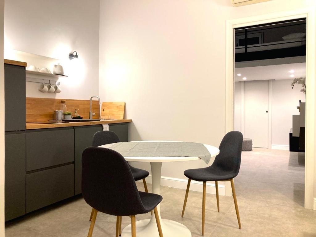 uma cozinha com uma mesa e quatro cadeiras em apartment rent Casa ALMIKA em Bari