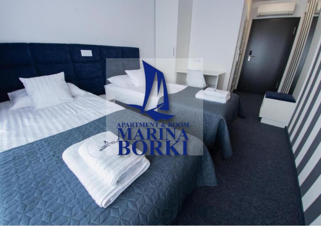 um quarto de hotel com uma placa para uma toalha britânica da marina em Pokoje - MARINA BORKI em Augustów