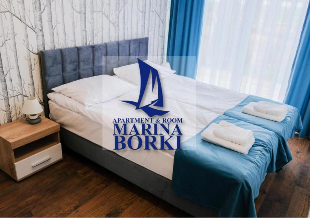 ein Schlafzimmer mit einem Bett mit einem Schild für den Yachthafen in der Unterkunft Apartamenty ZEFIR - MARINA BORKI in Augustów