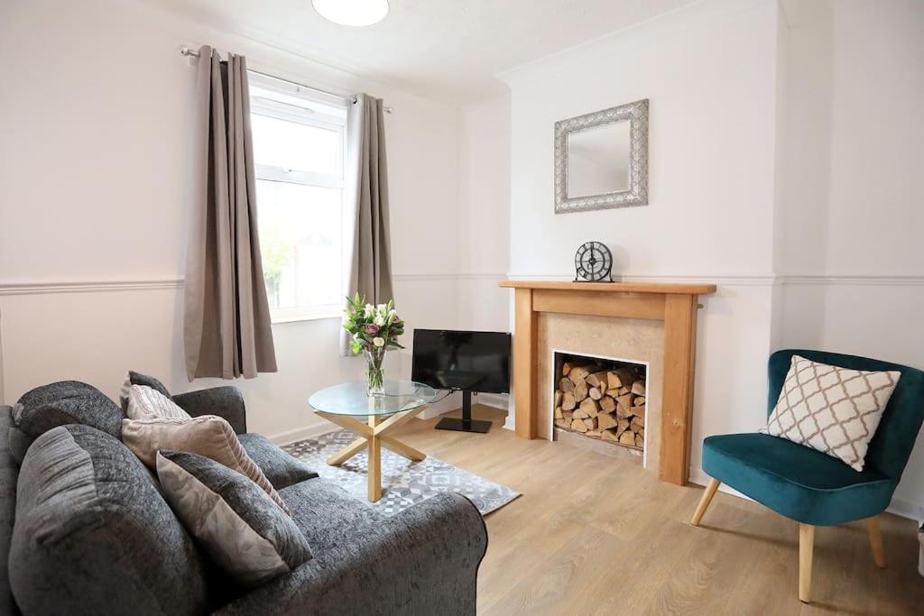 uma sala de estar com um sofá e uma lareira em Cowgate Rest em Norwich
