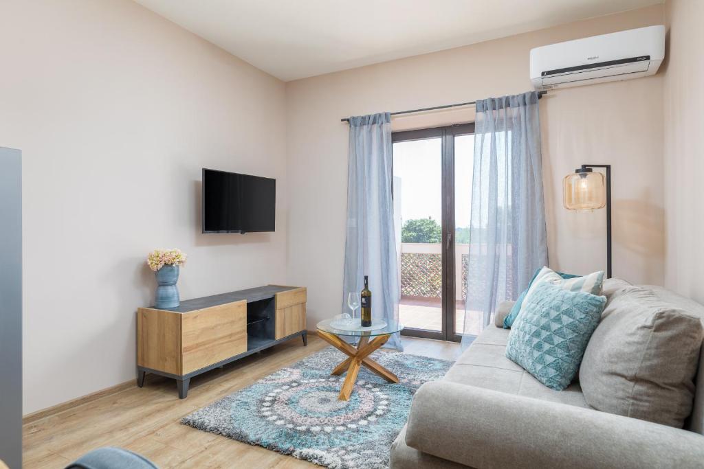 a living room with a couch and a tv at wine house apartments& rooms Marčeta in Fažana