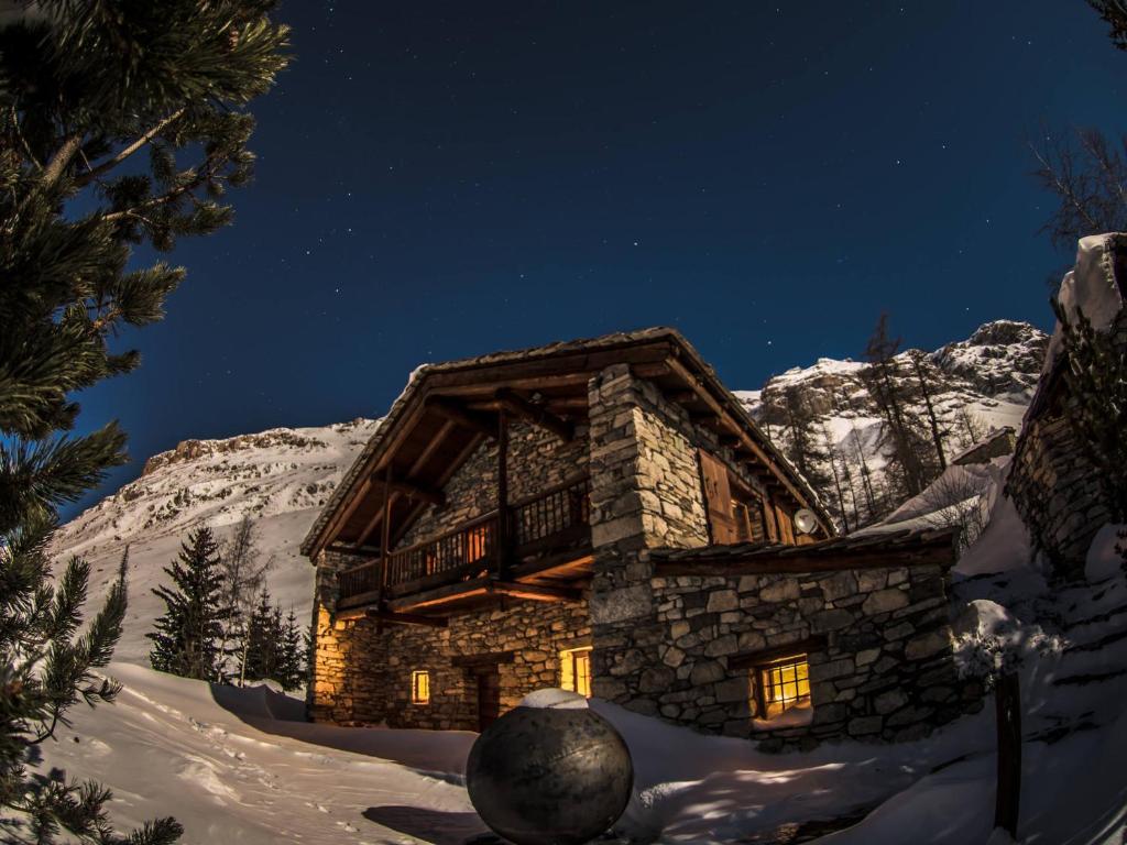 une cabane en rondins dans la neige la nuit dans l'établissement Chalet Val-d'Isère, 6 pièces, 12 personnes - FR-1-519-32, à Val dʼIsère