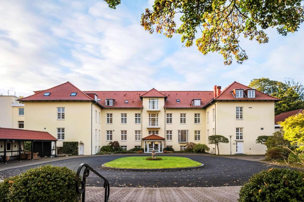 an exterior view of a large building with a circular driveway at Gl Skovridergaard in Silkeborg