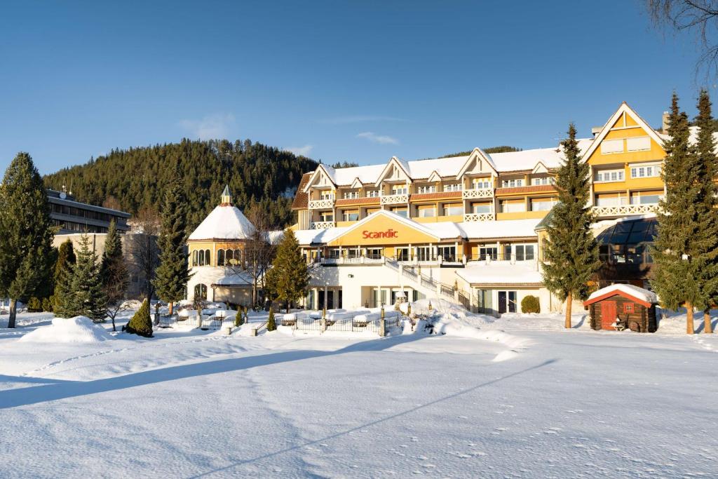 a large building in the snow with a snow covered street at Scandic Valdres in Fagernes