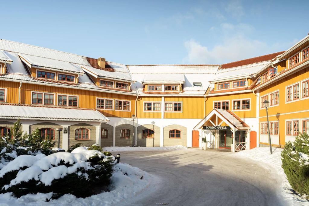 a large yellow building with snow on top of it at Scandic Hafjell in Hafjell