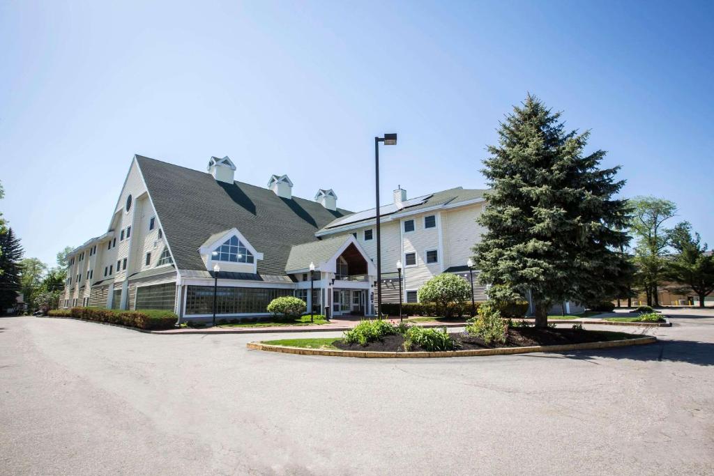 a large white building with a tree in a driveway at Comfort Inn in Concord