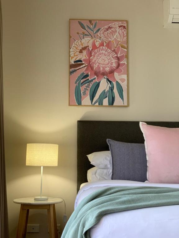 a bedroom with a bed and a table with a lamp at Shepparton Lakeside Serviced Apartment in Shepparton