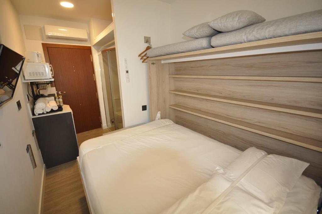 a small room with a bed and pillows at Habitación el Camarote de El Vinagrillo con parking cubierto incluido in Cartagena