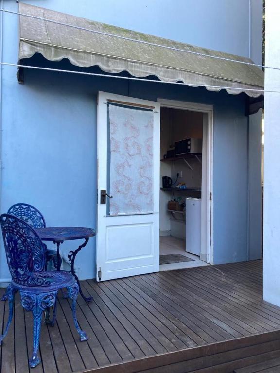 een tafel en een stoel op een terras met een deur bij Blue Cottage on Berea in Durban