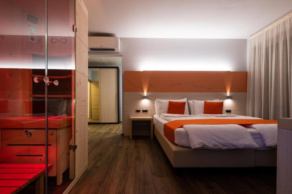 a bedroom with a large bed with an orange headboard at Albergo Casavecchia in Tiarno di Sopra