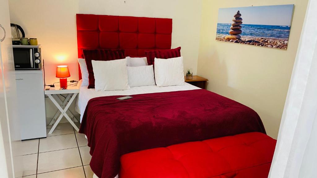 Schlafzimmer mit einem roten Bett mit einem roten Kopfteil in der Unterkunft Dundee Bun Private Room in Dundee