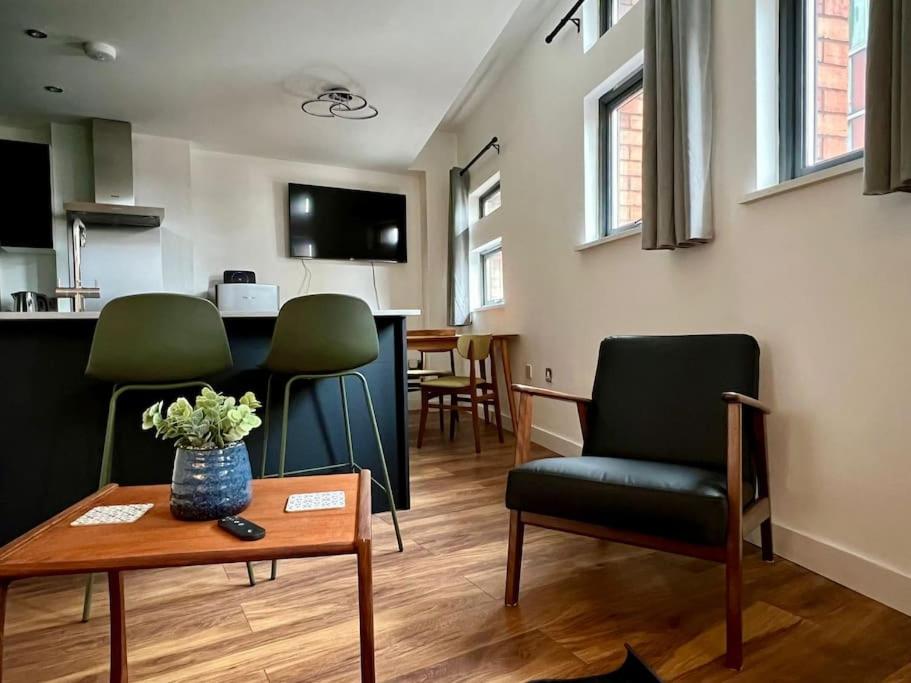 a living room with green chairs and a table at City SuperHost NQ & City Centre 1 BR with Parking in Manchester