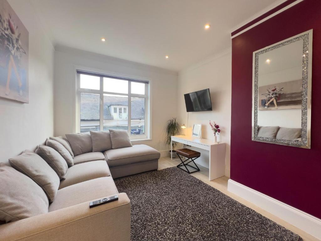 a living room with a couch and a mirror at The Dragon Pad Boutique Apartment in Royal Tunbridge Wells