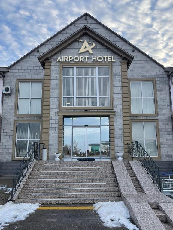 a airport hotel with stairs in front of it at Aktau Airport Hotel in Aktau