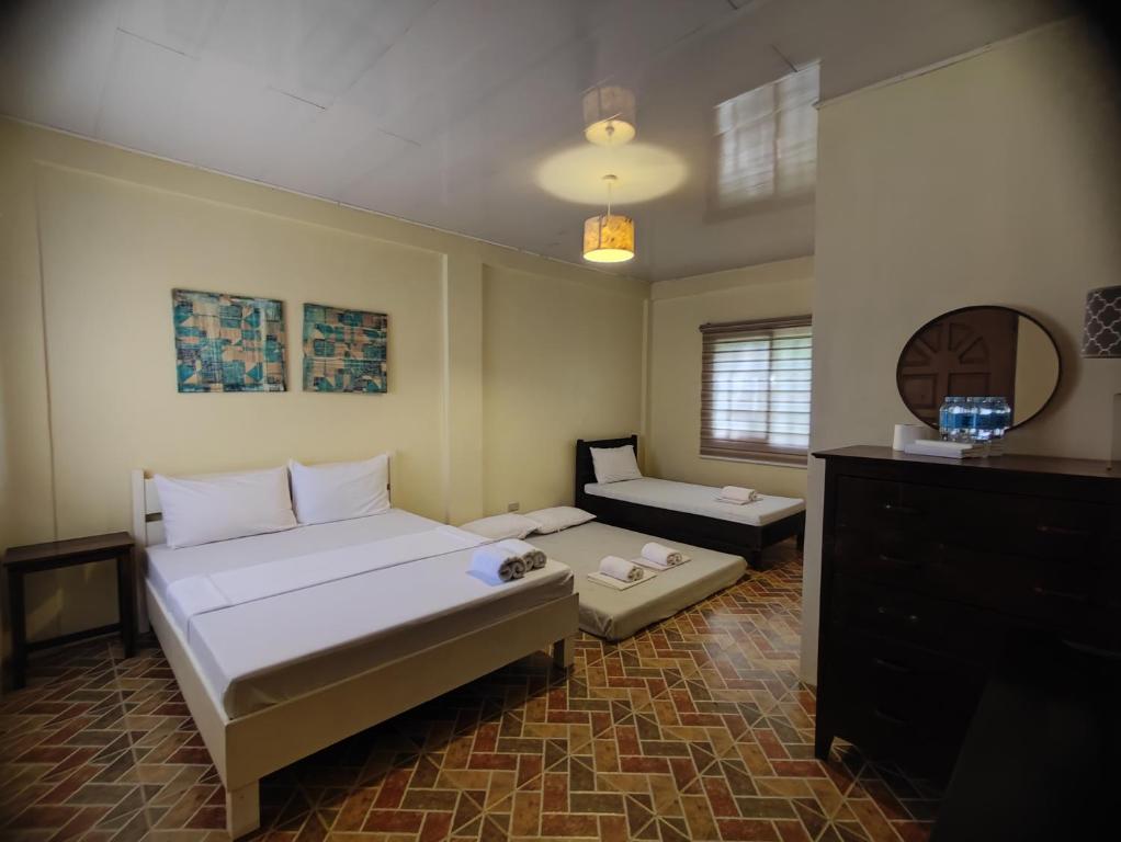 a bedroom with a large bed and a couch at Calicoan Villa in Sarog